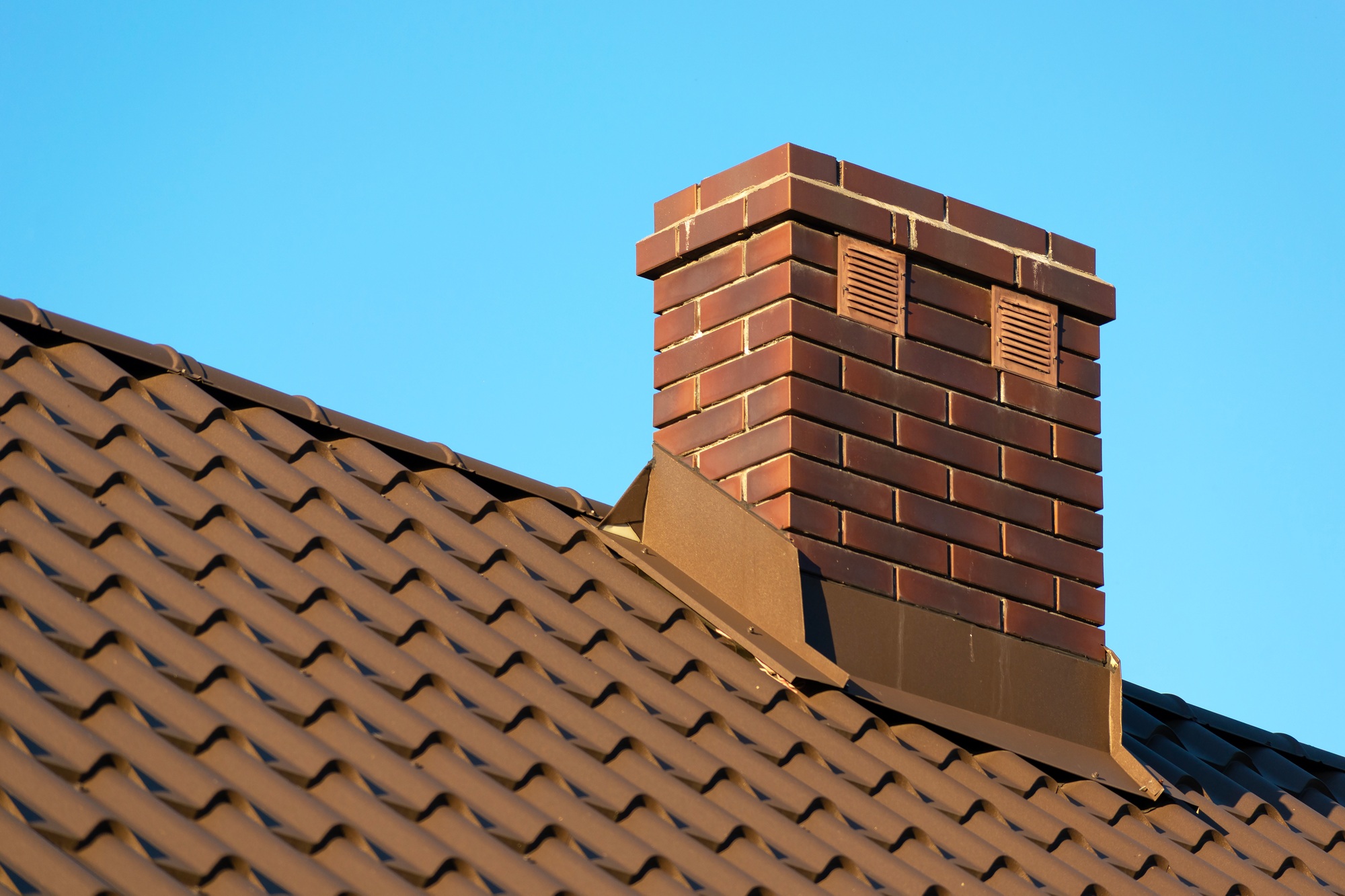 Brick chimney on the roof and blue sky