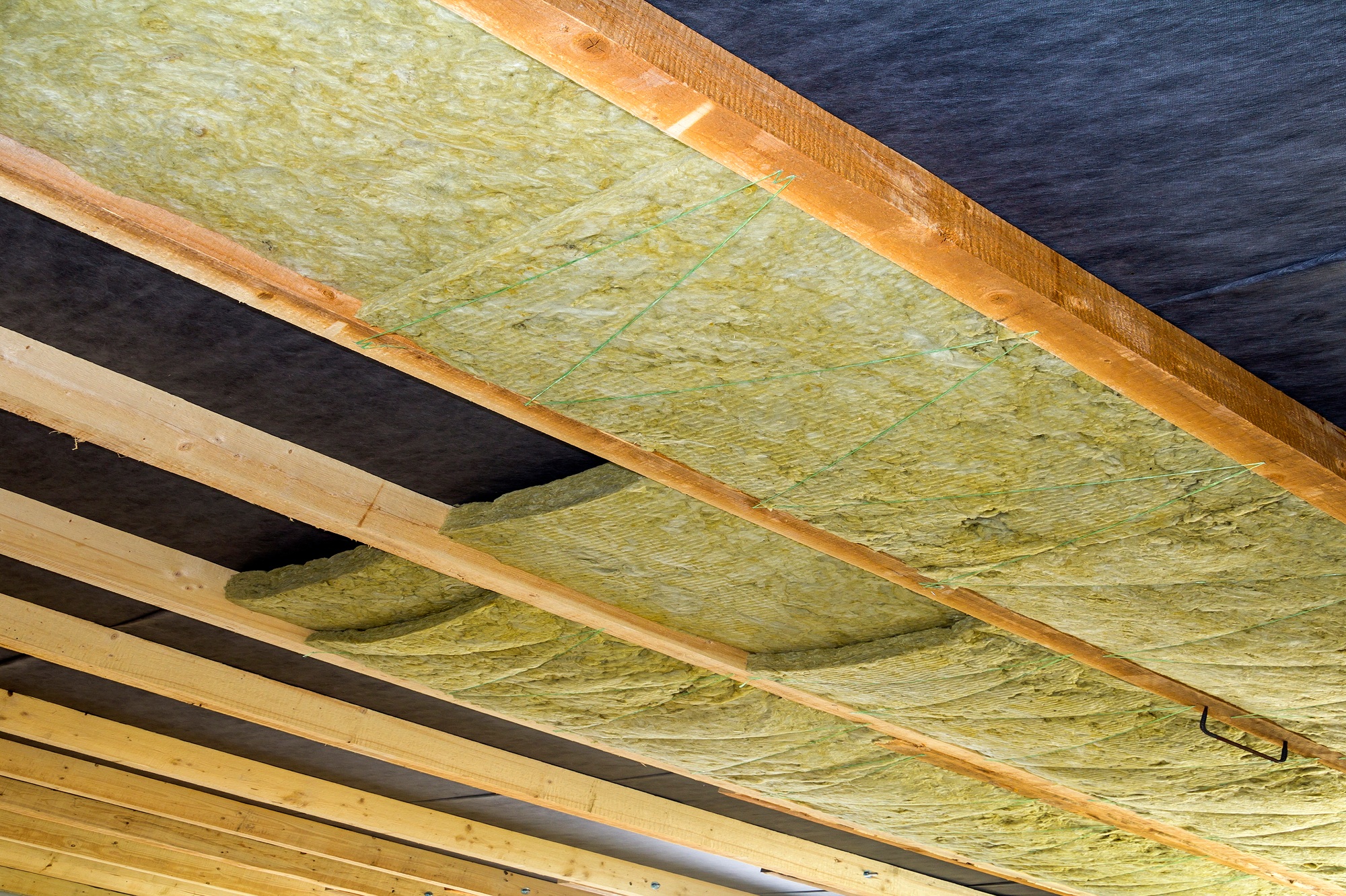 Thermal insulation mineral rock wool installation at the new building attic ceiling